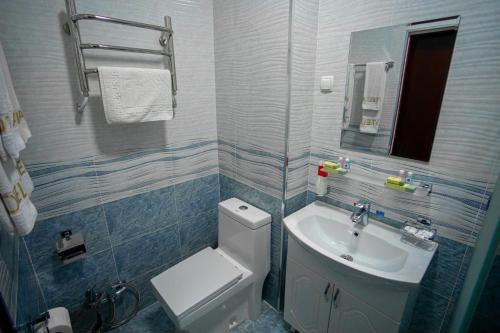 a bathroom with a white toilet and a sink at Hotel Asia Samarkand in Khodzha-Akhrar
