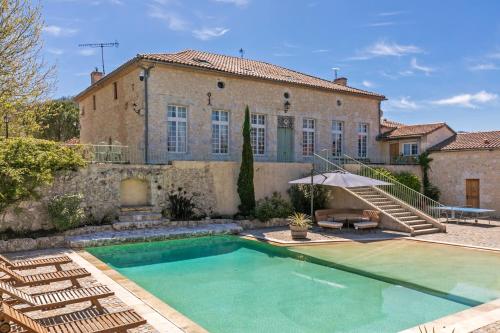 uma casa com piscina em frente a um edifício em Domaine de Rambeau em Castelmoron-sur-Lot