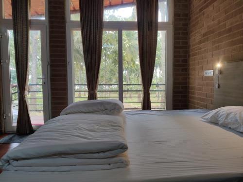 a bedroom with a large bed with pillows on it at Cosmic Connect Trails Kabini in Antarasante