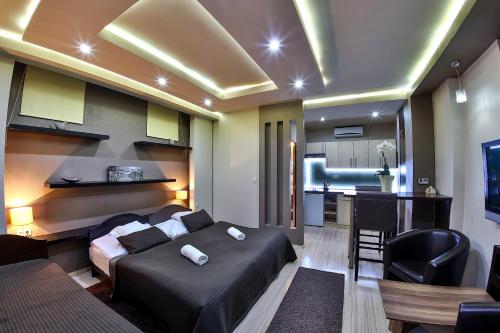a bedroom with a bed and a kitchen in a room at Royal Apartments Hotel Kecskemét in Kecskemét