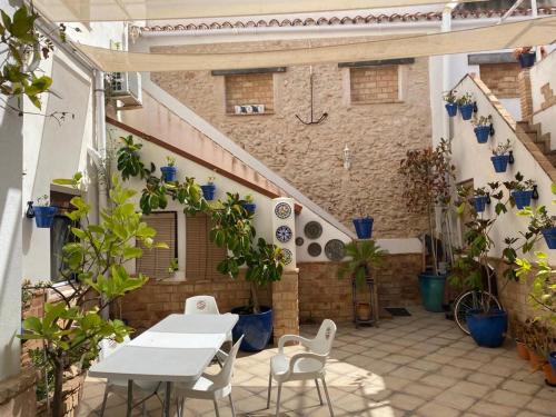 un patio al aire libre con mesas, sillas y plantas en Apartamento con Terraza,a 100m playa Costilla y Frente al Castillo, en Rota
