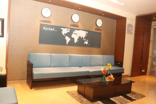 a living room with a couch and clocks on the wall at Kyriad Hotel Indore by OTHPL in Indore