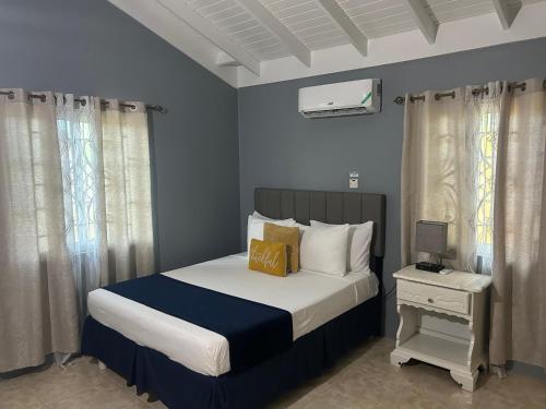 1 dormitorio con 1 cama con paredes y cortinas azules en Williams Oasis en Falmouth