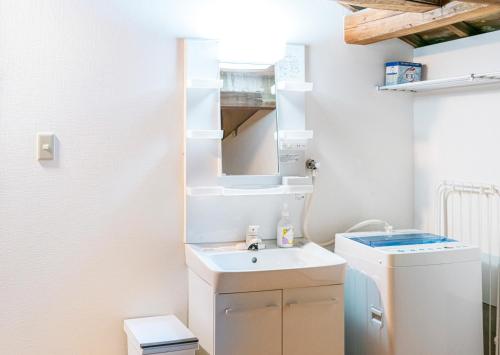 ふるシェアの家すさみ في Susami: حمام مع مغسلة وغسالة ملابس