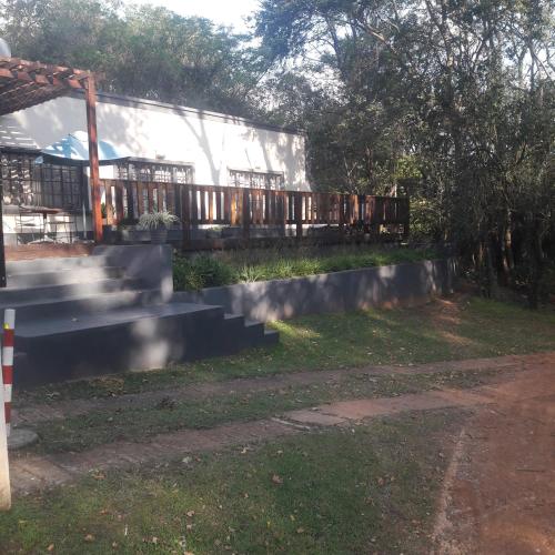 a building with a fence and stairs in a yard at Whispering Pines Country Estate in Magaliesburg
