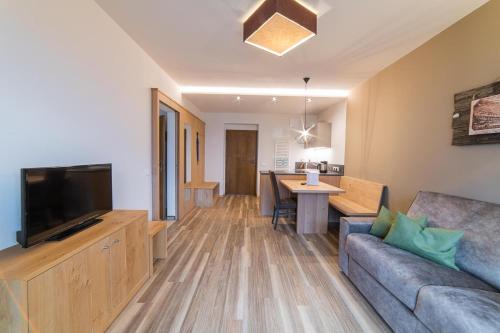 a living room with a couch and a television at Residence Sardis in Castelbello-ciardes