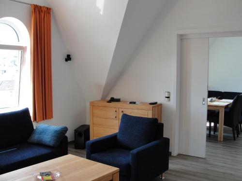 a living room with two chairs and a table at Hotel Berliner Hof by Coffee Fellows Hotels in Kiel