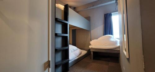 a small room with a bunk bed and a window at Rhodes Otsuka Hotel in Tokyo
