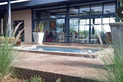 a swimming pool in the middle of a house at Hackberry House Black Thorn Cottage, Off Grid in Khemsbok