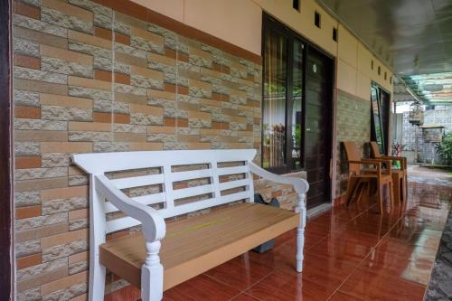 a bench sitting in front of a brick wall at RedDoorz Syariah @ Colomadu 2 in Solo