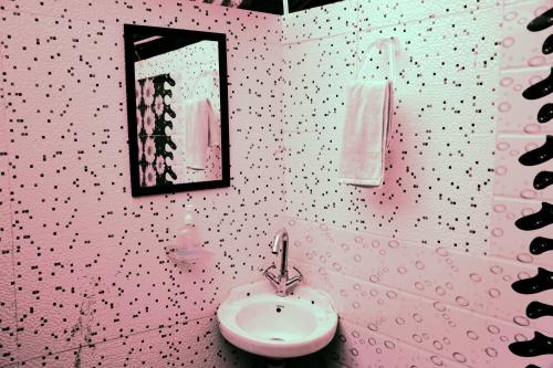uma casa de banho rosa com um lavatório e um espelho em FOREST ACRES CAMPS em Mukteshwar
