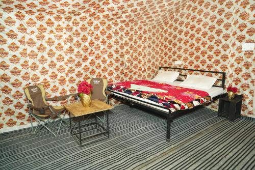 1 dormitorio con 1 cama, mesa y sillas en FOREST ACRES CAMPS en Mukteswar