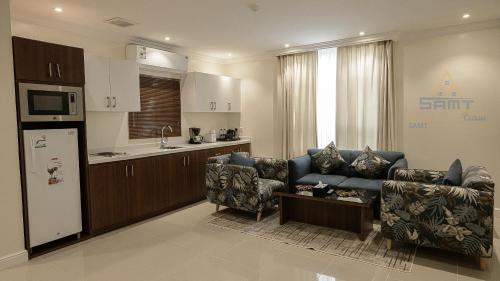 a living room with a couch and a kitchen at سمت للشقق المخدومة-الفيحاء in Riyadh