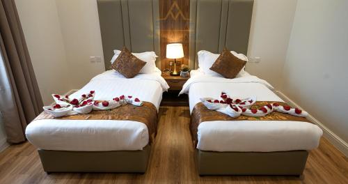 um quarto de hotel com duas camas com sapatos em سمت للشقق المخدومة-الفيحاء em Riade