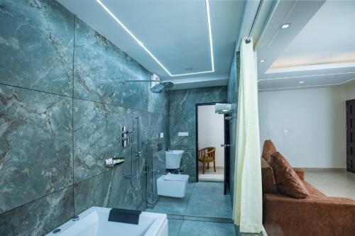 e bagno con doccia, servizi igienici e lavandino. di Alleppey Haven Beach Villa a Alleppey
