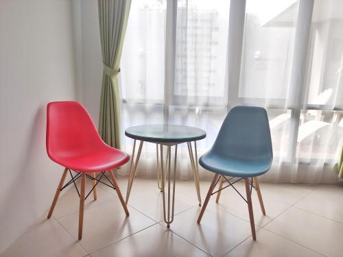 three chairs and a table in front of a window at Urbanest Inn House TB Simatupang in Jakarta