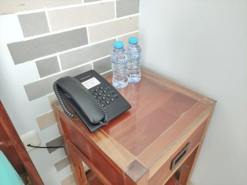 a desk with a phone and two bottles of water at Urbanest Inn House TB Simatupang in Jakarta