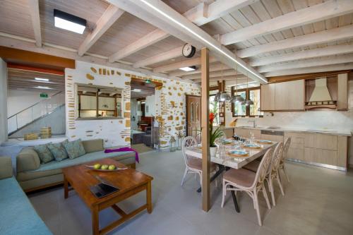 a kitchen and living room with a table and a couch at Villa Splantzia - Heated pool - Garden in Chania