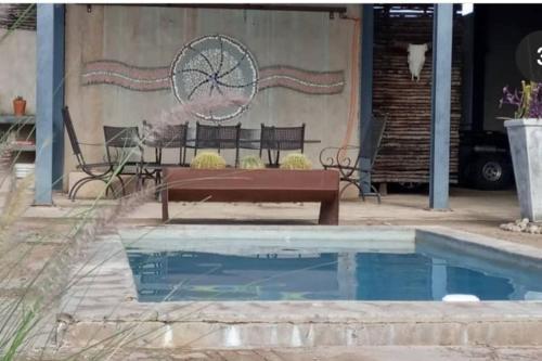 a pool with a bench and a table and a fountain at Hackberry House Bushwillow Cottage (Off Grid) in Khemsbok
