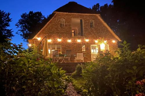 a brick house with lights on it at night at Warft Simmerdeis - Ferienwohnung 2 im EG in Oldenswort