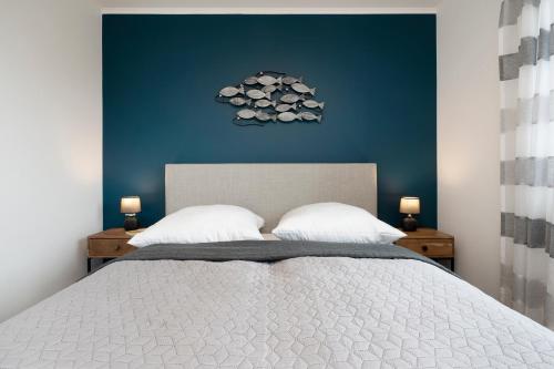 a bedroom with a large bed with a blue wall at Residenz am Yachthafen Seaside Marina in Neustadt in Holstein