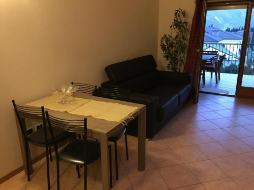 a living room with a table and a couch at Dream of the Lake - Garda Village in Riva del Garda