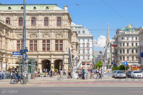 Luxury Suites Renngasse في فيينا: مجموعة من الناس تقطع شارع امام مبنى