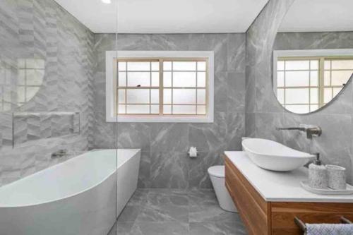 a bathroom with a tub and a sink and a toilet at Aria waterview in Point Clare