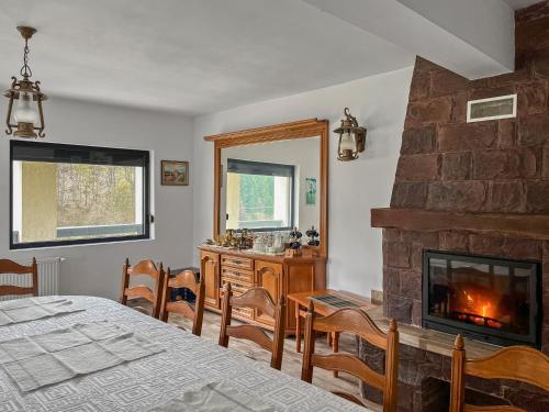 a bedroom with a fireplace and a table and chairs at Casa Șimon in Leordina