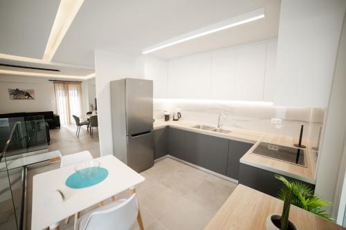 a kitchen and dining room with a table and a refrigerator at Athens Heart Luxury Penthouse in Athens