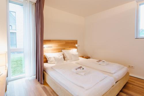 1 dormitorio con 1 cama grande con sábanas blancas en M2 Living Apartment No 5, en Prerow