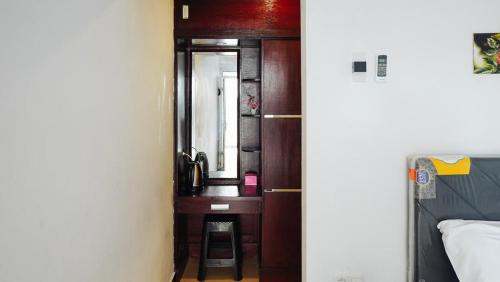 a bedroom with a wooden door with a mirror at Koolkost Syariah near RSUD Mataram Lombok in Mataram