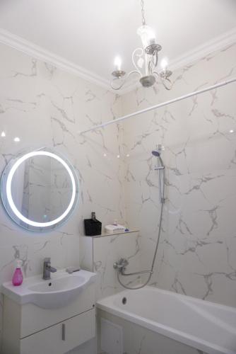 uma casa de banho branca com um lavatório e um espelho em Home Apart em Astana