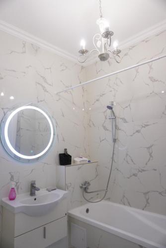 ein weißes Badezimmer mit Waschbecken und Spiegel in der Unterkunft Home Apart in Astana
