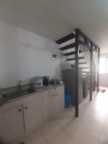 a kitchen with a sink and a staircase in a room at salty dog homestay in Batangas City