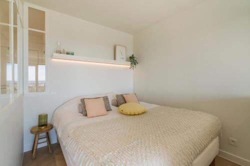 - une chambre avec un lit doté d'un oreiller jaune dans l'établissement Lighthouse studio with amazing & beautiful sea view, à Nieuport