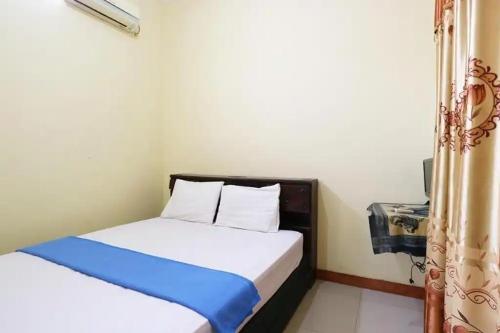 a small bedroom with a bed and a window at Hotel Serasi 2 in Tangerang