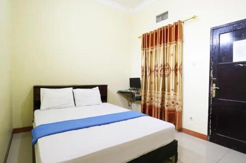 丹格朗的住宿－Hotel Serasi 2，一间卧室配有一张床和一张书桌