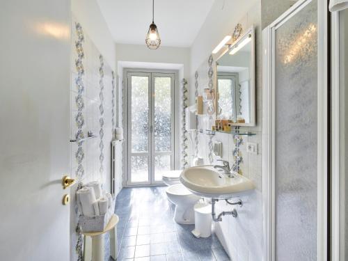 a white bathroom with a sink and a toilet at Hotel San Marco in Garda