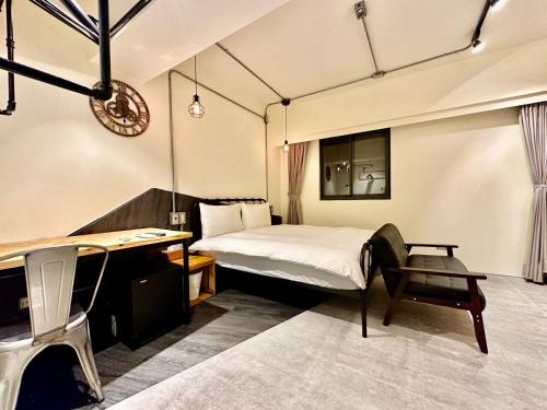 een slaapkamer met een bed, een bureau en een stoel bij 小鹿 Homestay in Taichung