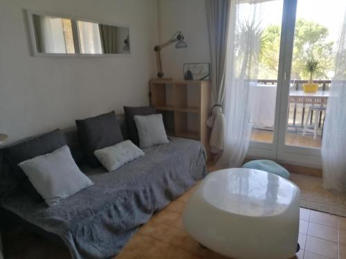 uma sala de estar com um sofá e uma mesa de centro em Sanary les gorguettes, studio avec terrasse vue mer, à 10 min à pieds de la plage em Sanary-sur-Mer