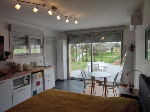 une cuisine avec une table et des chaises ainsi qu'une salle à manger dans l'établissement Les Gîtes De La Caneda, à Sarlat-la-Canéda