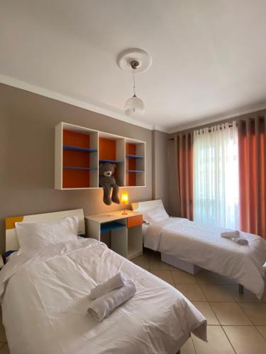 a hotel room with two beds and a teddy bear on a desk at Cloud8 Apt with Castle View, 7km from the Beach in Lezhë