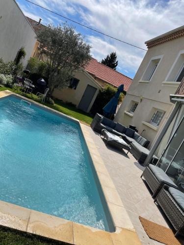 - une piscine avec 2 chaises longues et une maison dans l'établissement Villa Madhi - Piscine privée, à LʼIsle-sur-la-Sorgue