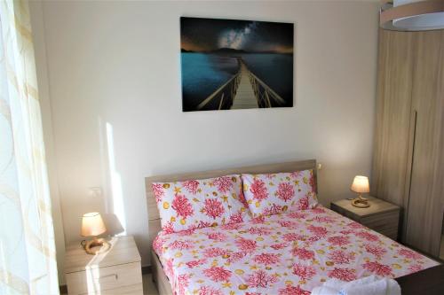 a bedroom with a bed with a pink comforter at LA CASA DI CHLOE in Marzamemi