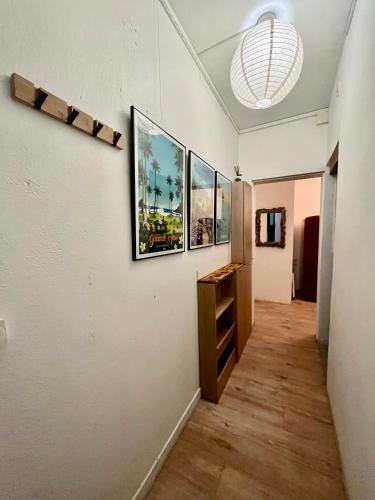 a hallway with three paintings on the wall at Lelaleu in Saint-Leu