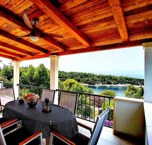 einen Tisch und Stühle auf einem Balkon mit Blick auf das Wasser in der Unterkunft Seaview Residence in Splitska