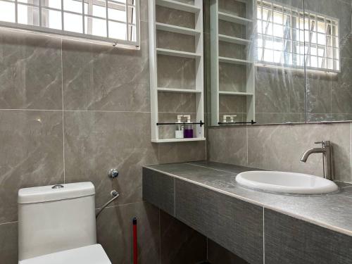 un bagno con un water, un lavandino e uno specchio di Home in Bandar Baru Bangi a Bandar Baru Bangi