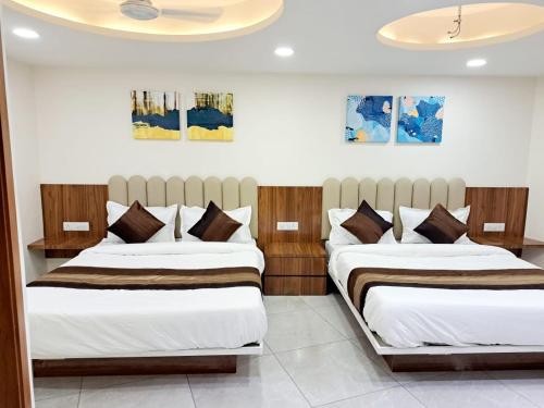 two beds in a hotel room with two bedsvisor at Hotel Pratham Inn in Ahmedabad