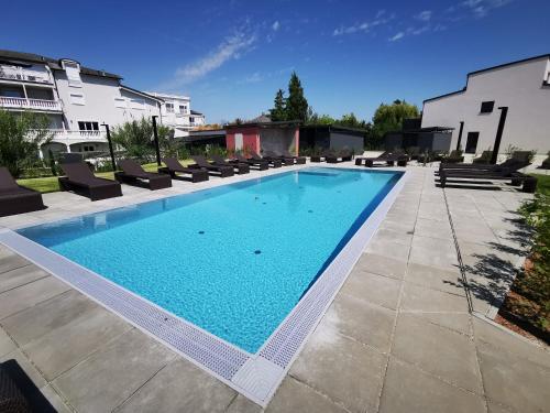 uma grande piscina com espreguiçadeiras em redor em SPA RESIDENZ NEUSIEDL APPARTMENTS em Neusiedl am See